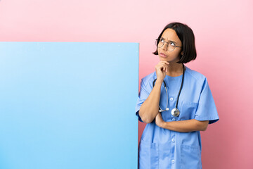Young mixed race surgeon woman with a big banner over isolated background having doubts