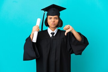 Young university graduate girl over isolated blue background showing thumb down with two hands