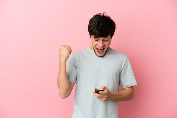 Young Russian man isolated on pink background surprised and sending a message