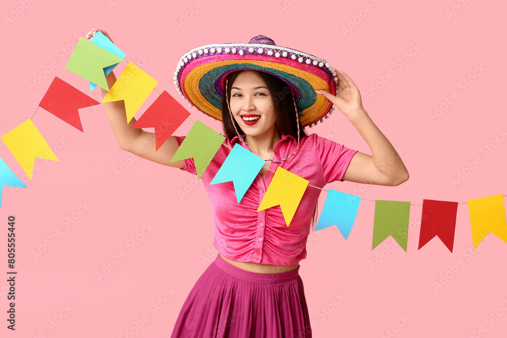 Sticker Happy young woman in Mexican sombrero hat and with festive garland on pink background