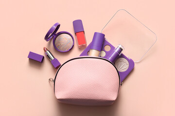 Pink cosmetic bag with makeup products on beige background