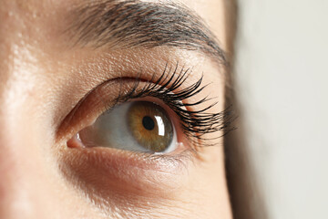 Macro photo of woman with beautiful eyes on light background