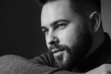 Portrait of handsome bearded man on dark background. Black and white effect