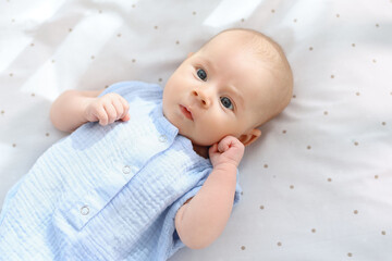 Cute little baby lying in crib at home, top view