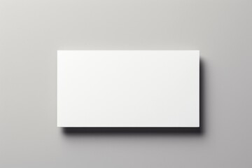 A simple blank white rectangular box or panel placed horizontally on a gray marble surface, casting a soft shadow beneath.