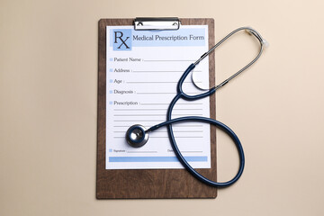 Clipboard with medical prescription form and stethoscope on beige background, flat lay