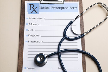 Clipboard with medical prescription form and stethoscope on beige background