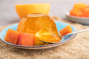 Papaya and orange jelly on gray concrete and linen textile. side view, selective focus.