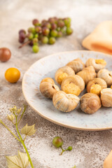 Grape (Burgundy) snails with butter and cheese on brown concrete, side view, selective focus