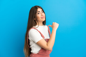 Young caucasian woman isolated on blue background proud and self-satisfied