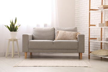 Interior of stylish living room with grey sofa and light curtains