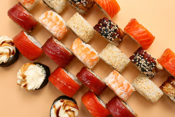 Tasty sushi rolls on beige background