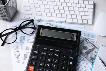 Tax accounting. Calculator, documents, keyboard, stationery and glasses on light grey table, above...