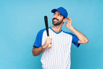 Young man playing baseball over isolated blue background thinking an idea