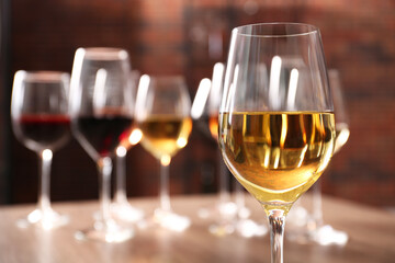 Fototapeta premium Tasty white wine in glass against blurred background, space for text