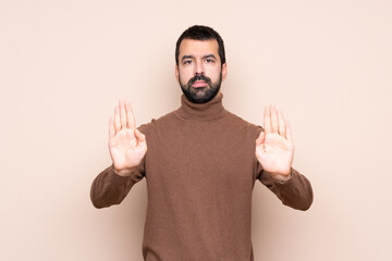Man over isolated background making stop gesture and disappointed