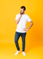 Full-length shot of man with beard over isolated yellow background with toothache