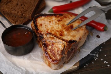 Tasty grilled meat, chili and marinade on table, closeup