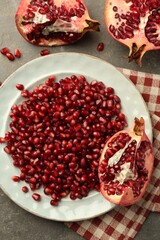 Tasty ripe pomegranate and grains on grey table, flat lay