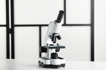 Modern medical microscope on white table indoors