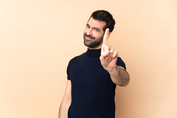 Caucasian handsome man over isolated background showing and lifting a finger