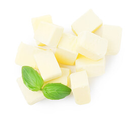 Pile of tasty butter cubes and basil leaves isolated on white, top view