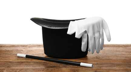 Magician's hat, gloves and wand on wooden table against white background