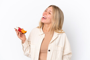 Young caucasian woman holding sashimi isolated on white background laughing in lateral position