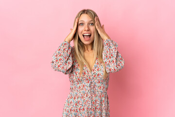 Young blonde woman isolated on pink background with surprise expression