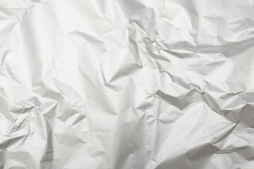 Obraz premium Crumpled silver foil as background, top view