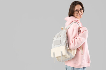 Happy female student with backpack on white background