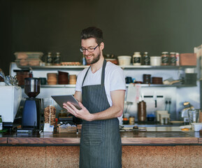 Man, barista and tablet for order or sale in coffee shop for hospitality, take away and employee in...