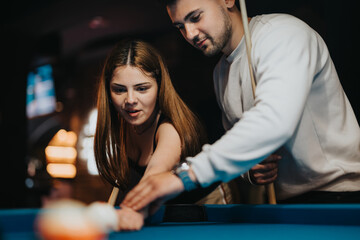 A group of young friends enjoy a fun and leisurely game of pool, showcasing teamwork and carefree...