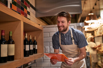 Man, clipboard and wine on shelf in restaurant for alcohol, inventory and management for...