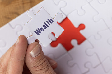 Blank puzzle with the missing piece being held next to the whole with a red placer where the last...