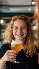 A woman smiling while holding a glass of beer