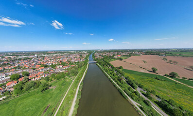 Aerial view of river with fields, houses, trees, and urban design Mittellandkanal panoramic drone...