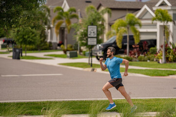 Handsome middle aged man running across american neighborhood. Athletic man running outdoor....