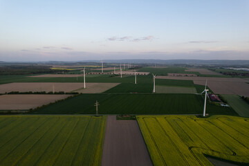 Obraz premium Aerial view of wind turbines in a grassy field under a cloudy sky 5K drone view Hanover Wunstorf Kolenfeld Germany 