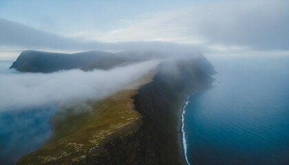 aerial view of north cape aka nordkapp in summer with fog clouds over the landscape in northern norway