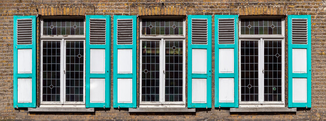 Traditional flemish wooden window shutters in turquoise colors, Gistel, Bruges region, West Flanders, Belgium.