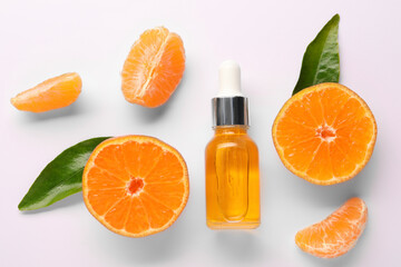 Aromatic tangerine essential oil in bottle, leaves and citrus fruits on white table, flat lay
