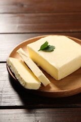 Cut tasty butter with parsley on wooden table