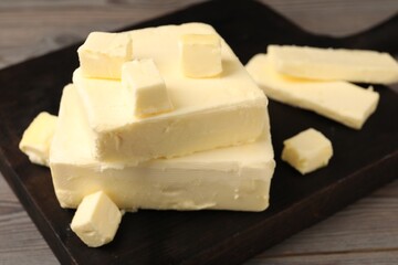 Pieces of tasty butter on wooden table, closeup