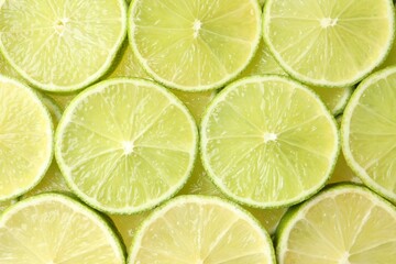 Fresh juicy lime slices as background, top view