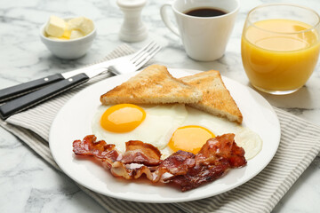 Delicious breakfast with sunny side up eggs served on white marble table, closeup