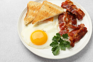 Delicious breakfast with sunny side up egg on light table, closeup