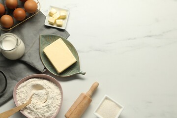 Flat lay composition with fresh butter among other products on white marble table. Space for text