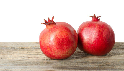Fresh pomegranates on wooden table against white background, space for text