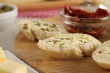 Tasty butter with spices and bread on table, closeup